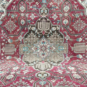 May include: A vintage Persian rug with a intricate floral pattern in shades of red, blue, and white. The rug has a central medallion and a border with a repeating design.