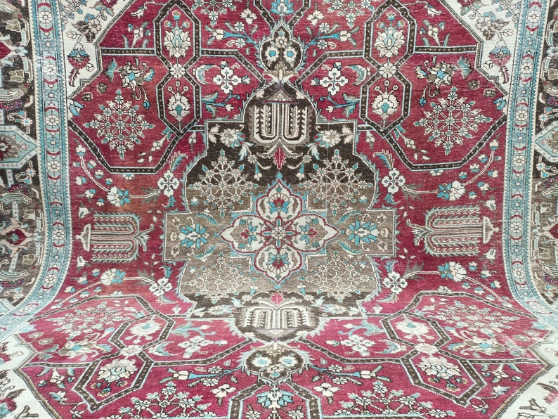 May include: A vintage Persian rug with a intricate floral pattern in shades of red, blue, and white. The rug has a central medallion and a border with a repeating design.