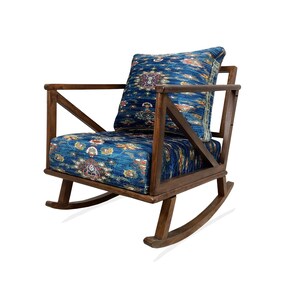 A wooden rocking chair with a blue and white patterned cushion.