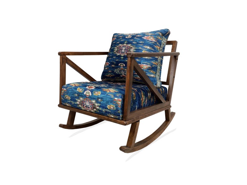 A wooden rocking chair with a blue and white patterned cushion.