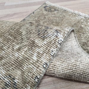 May include: Two beige and brown woven rugs with a fringed edge. The rugs are folded in half and are made of a soft, textured material.