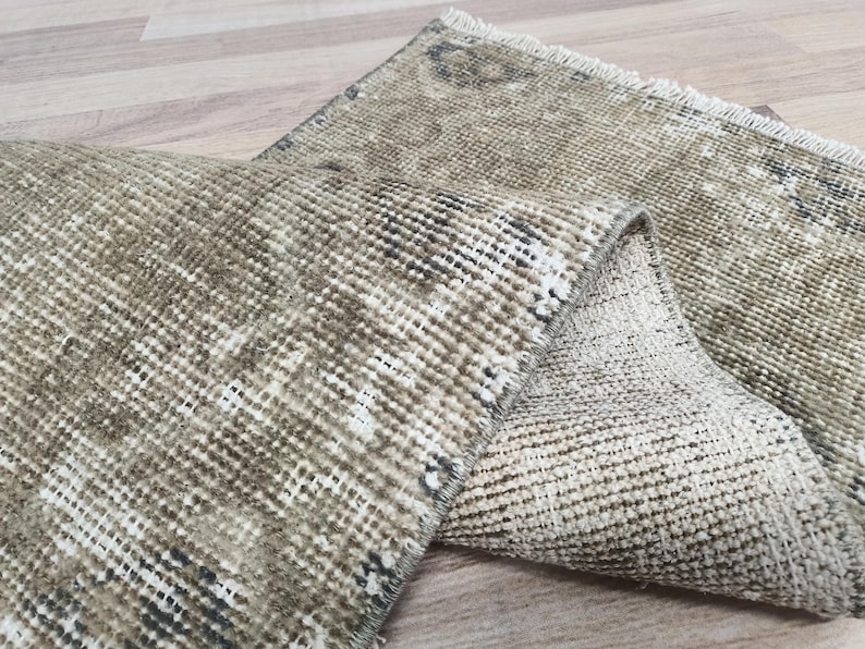 May include: Two beige and brown woven rugs with a fringed edge. The rugs are folded in half and are made of a soft, textured material.