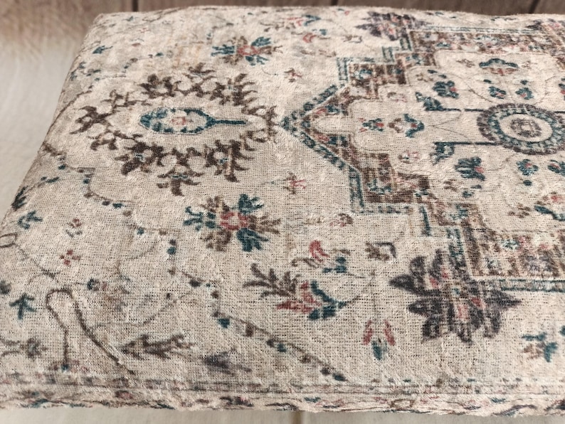 a close-up view of a decorative rug or cushion with a floral pattern.
