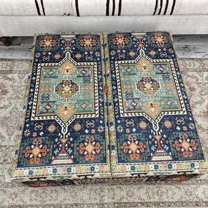 May include: Two blue and orange patterned ottoman cushions with intricate designs. The cushions are made of a soft, plush fabric and have a traditional look.