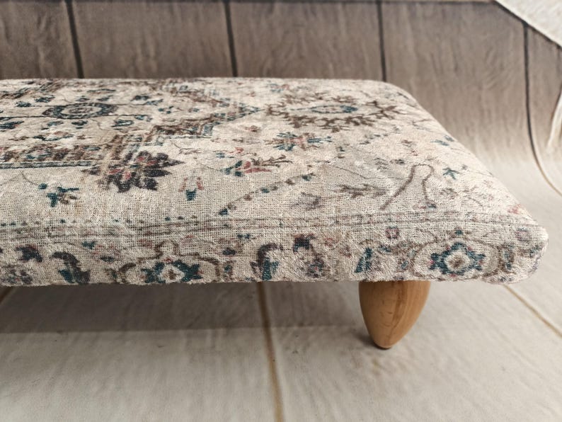 A close-up view of a decorative rug with intricate patterns and designs, placed on a wooden floor.