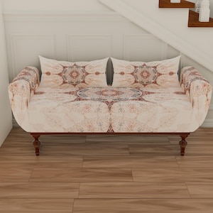 May include: A white and beige patterned sofa with a wooden frame and legs. The sofa has two pillows with a similar pattern.