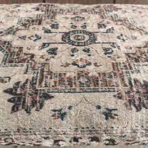a close-up view of a decorative rug or carpet with intricate patterns and designs.