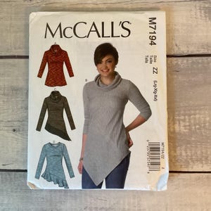 May include: McCall's sewing pattern M7194 for a long-sleeve top with a cowl neck and asymmetrical hemline. The envelope displays four variations of the top in red, olive green, gray, and blue, with size ZZ for Lrg-Xlg-Xxl and a barcode.