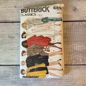 May include: A Butterick Classics 6850 sewing pattern envelope featuring illustrations of various cape and coat styles in colors including red, brown, black, and yellow. The envelope includes text such as Very Easy, Fast & Easy, and size L-XL.