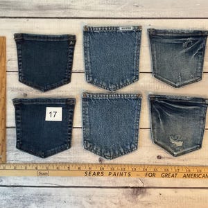 Puede incluir: Seis bolsillos de mezclilla azul dispuestos en dos filas de tres. Los bolsillos var&iacute;an en tono de azul oscuro a claro, algunos con detalles desgastados. Una regla de madera est&aacute; colocada vertical y horizontalmente, mostrando medidas en cent&iacute;metros.