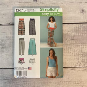 May include: A Simplicity 1367 sewing pattern envelope for sizes 16-24. The front displays illustrations of skirts, pants, and shorts with fold-over waistbands, alongside photographs of models wearing a chevron maxi skirt and light-colored shorts.