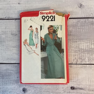 May include: A Simplicity 9221 sewing pattern envelope for a size 10 miss. The red and white packaging features illustrations of a long robe and a slip dress, with a photograph of a person wearing the light green robe with a tie belt.