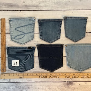 Puede incluir: Seis bolsillos de mezclilla variados en diferentes tonos de azul, dispuestos en dos filas. Una regla de madera a la izquierda muestra una altura de 20 cm, y una regla horizontal en la parte inferior indica un ancho de 53 cm. Un bolsillo tiene el n&uacute;mero 21.