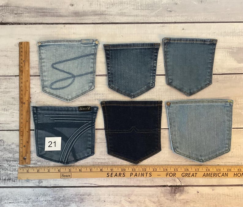 Puede incluir: Seis bolsillos de mezclilla variados en diferentes tonos de azul, dispuestos en dos filas. Una regla de madera a la izquierda muestra una altura de 20 cm, y una regla horizontal en la parte inferior indica un ancho de 53 cm. Un bolsillo tiene el n&uacute;mero 21.