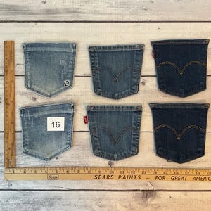 Puede incluir: Seis bolsillos de mezclilla dispuestos en dos filas de tres. Los bolsillos var&iacute;an en tonos de azul, de claro a oscuro. Una regla de madera est&aacute; colocada verticalmente a la izquierda y horizontalmente en la parte inferior, mostrando medidas en cm. El n&uacute;mero 16 es visible.