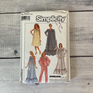 May include: Simplicity sewing pattern package featuring illustrations of various sleepwear designs. The package includes a dress, a long robe, a pajama set, and a nightgown. The package is white with the Simplicity logo and product information.