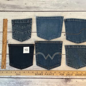 Pode incluir: Seis bolsos de ganga azul sortidos dispostos em duas filas, com uma r&eacute;gua de madeira &agrave; esquerda de 30,5 cm e uma r&eacute;gua horizontal na parte inferior de 53,3 cm. Um bolso azul escuro tem uma etiqueta quadrada branca com o n&uacute;mero 10.