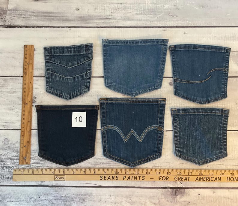 Pode incluir: Seis bolsos de ganga azul sortidos dispostos em duas filas, com uma r&eacute;gua de madeira &agrave; esquerda de 30,5 cm e uma r&eacute;gua horizontal na parte inferior de 53,3 cm. Um bolso azul escuro tem uma etiqueta quadrada branca com o n&uacute;mero 10.