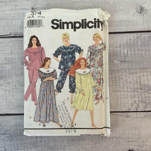 May include: A Simplicity sewing pattern envelope, number 574, size A (PT-XL). The front features illustrations of five different sleepwear styles, including pajama sets and nightgowns with floral and polka dot patterns, plus a Jo-Ann Fabrics store stamp.