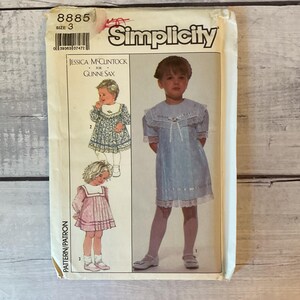 May include: A Simplicity sewing pattern envelope, number 8885, size 3, for a Jessica McClintock for Gunne Sax dress. The cover features illustrations and a photograph of a child wearing a light blue dress with a wide lace collar, short sleeves, and ribbon trim.