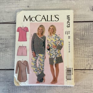 May include: A McCall's sewing pattern envelope, MP473, featuring illustrations of loungewear including a wrap top, shorts, pants, and a robe. The patterns display various floral and geometric prints in pink, yellow, blue, and grey. Size B5 is listed.