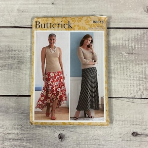 May include: A Butterick sewing pattern featuring two women modeling skirts and tops. The pattern cover has the text "Butterick" and "B6818". The woman on the left is wearing a red floral skirt and the woman on the right is wearing a striped skirt.