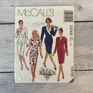 May include: A McCall's 5249 sewing pattern envelope for size 14, featuring illustrations of four different skirt suit styles in white, floral print, navy blue, and magenta. The front cover displays the brand name, pattern number, and size.