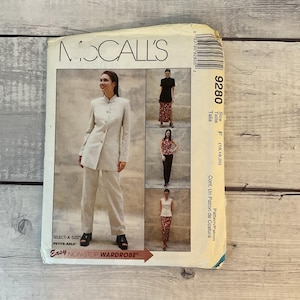 May include: A vintage McCall's sewing pattern featuring a woman in a beige suit. The pattern includes multiple outfit options, including a black top and patterned skirt. The pattern size is F (16,18,20). The text on the pattern reads "Easy Non-Stop Wardrobe."