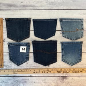 Pode incluir: Seis bolsos de ganga variados em v&aacute;rios tons de azul, dispostos em duas filas. Uma r&eacute;gua de madeira &agrave; esquerda mostra uma altura de 15,24 cm, e uma r&eacute;gua horizontal na parte inferior mostra uma largura de 55,88 cm. Um bolso apresenta o n&uacute;mero 14.