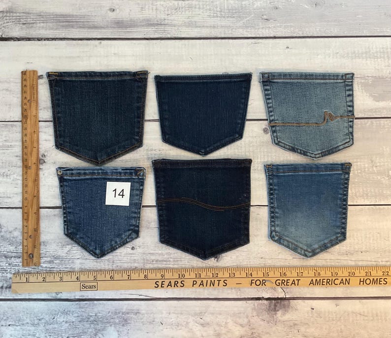 Pode incluir: Seis bolsos de ganga variados em v&aacute;rios tons de azul, dispostos em duas filas. Uma r&eacute;gua de madeira &agrave; esquerda mostra uma altura de 15,24 cm, e uma r&eacute;gua horizontal na parte inferior mostra uma largura de 55,88 cm. Um bolso apresenta o n&uacute;mero 14.