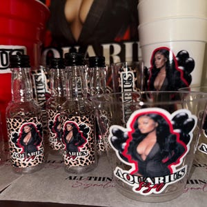 May include: A set of clear glass bottles and cups with custom labels featuring a woman in a black outfit with the text "Aquarius SZN" and a leopard print background.