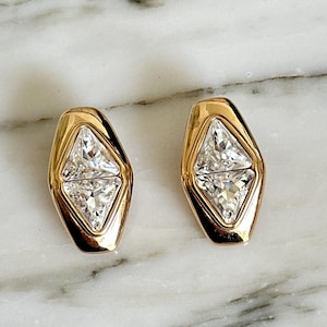 May include: A set of three ceramic mugs with a speckled, matte finish. Each mug features a different color: light blue, cream, and gray. The mugs have a simple, modern design and a comfortable handle.