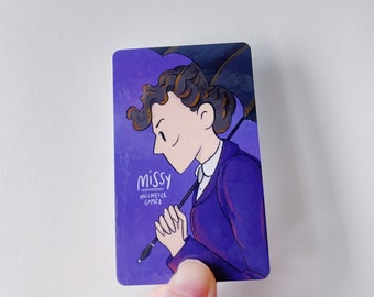 May include: A purple and black illustrated sticker featuring a character named "Missy" with a black umbrella. The text "Missy Michelle Gomez" is printed on the sticker.