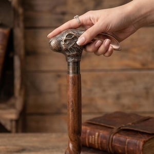 Puede incluir: Bast&oacute;n decorativo con un mango de cabeza de conejo de bronce y un eje de madera oscura. El mango est&aacute; detallado con los rasgos del conejo, y el eje tiene un dise&ntilde;o retorcido. El bast&oacute;n es un accesorio elegante.