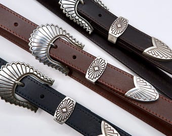 May include: Three belts in black, brown, and dark brown, each featuring a silver-toned metal buckle with a fan-shaped design, a matching rectangular keeper, and a pointed tip end piece, all displaying a consistent sunburst-inspired pattern.