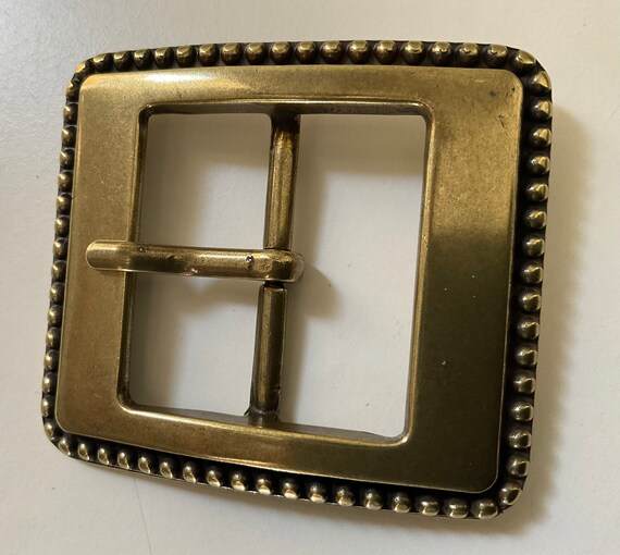 Clean,classic centre bar belt buckle with rivet borde… - Gem