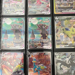 May include: A collection of eight Pokémon trading cards displayed in a plastic binder sleeve. The cards feature various characters including Rayquaza VMAX, Gengar VMAX, Umbreon VMAX, Tyranitar V, Blaziken VMAX, Machamp V, and Lugia V with colorful illustrations.