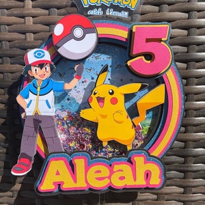 May include: A colorful Pokemon themed cake topper with a Pikachu, a Pokeball, and the number 5. The topper also includes the name Aleah in yellow letters with a pink outline.