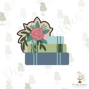 May include: A stack of three books with a floral design on top. The books are blue, green, and light blue. The floral design is pink, green, and white.