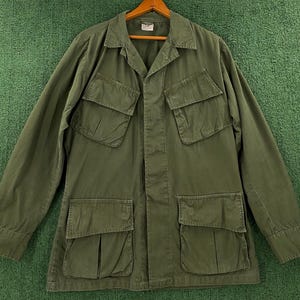 Peut inclure: Une veste utilitaire verte avec plusieurs poches et un devant boutonné.
