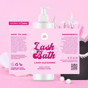 Può includere: Una bottiglia rosa e bianca di detergente per ciglia Lash Bath con dosatore a pompa. L'etichetta presenta il testo "Lash Bath" in un font retrò, insieme a istruzioni e ingredienti. Un contenitore nero con spazzole per ciglia rosa sullo sfondo.