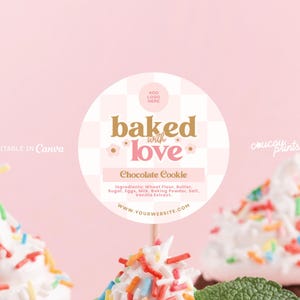 May include: A circular sticker design featuring a light pink and white checkered pattern with the text baked with love, Chocolate Cookie, and a list of ingredients. The design includes a placeholder for a logo and website, with small flower icons.