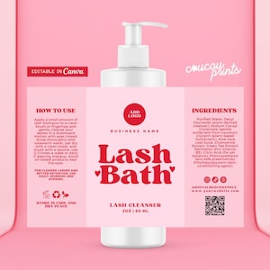 Pode incluir: Uma garrafa branca com bomba e rótulo rosa com "Lash Bath" em vermelho. O rótulo inclui instruções, ingredientes e um código QR. Contém 60 ml de limpador de cílios.