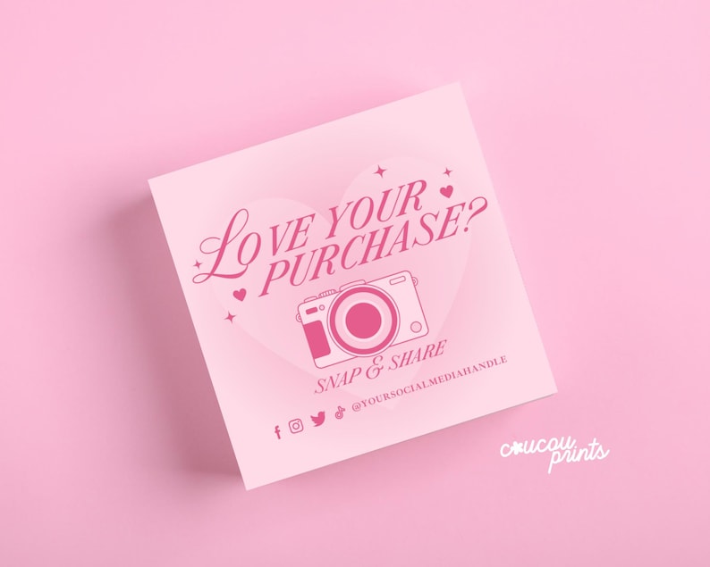 May include: A square light pink card featuring a dark pink heart graphic, a camera icon, and the text LOVE YOUR PURCHASE? SNAP & SHARE. Below are social media icons and the placeholder text @YOURSOCIALMEDIAHANDLE, with coucou prints in the corner.