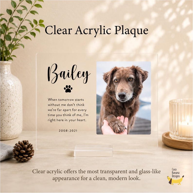 Puede incluir: Una placa de acr&iacute;lico transparente con el nombre Bailey, un icono de huella, las fechas 2008-2021 y un poema conmemorativo. A la derecha, una foto rectangular muestra a un perro marr&oacute;n con una mano tocando su pata. La placa tiene una base.