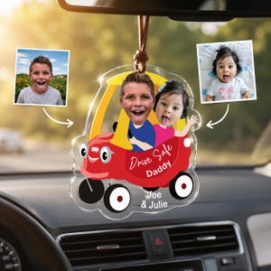 May include: A personalized car ornament featuring a red and yellow cartoon car with the text "Drive Safe Daddy." The ornament includes two photos and the names "Joe & Julie" at the bottom. It hangs from a brown leather cord.