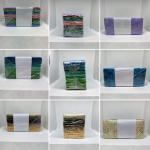May include: Nine stacks of fabric squares, each stack wrapped in plastic and tied with a ribbon. The fabric squares are in various colours and patterns, including green, blue, purple, pink, and yellow.