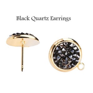 May include: A pair of gold stud earrings with black quartz stones. The earrings are round and have a smooth, polished finish.