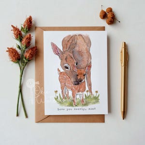 May include: A watercolor illustration of a mother deer and her fawn. The deer are brown with white spots. The fawn is nestled against its mother's neck. The text "Love you deerly, mom!" is written below the deer.