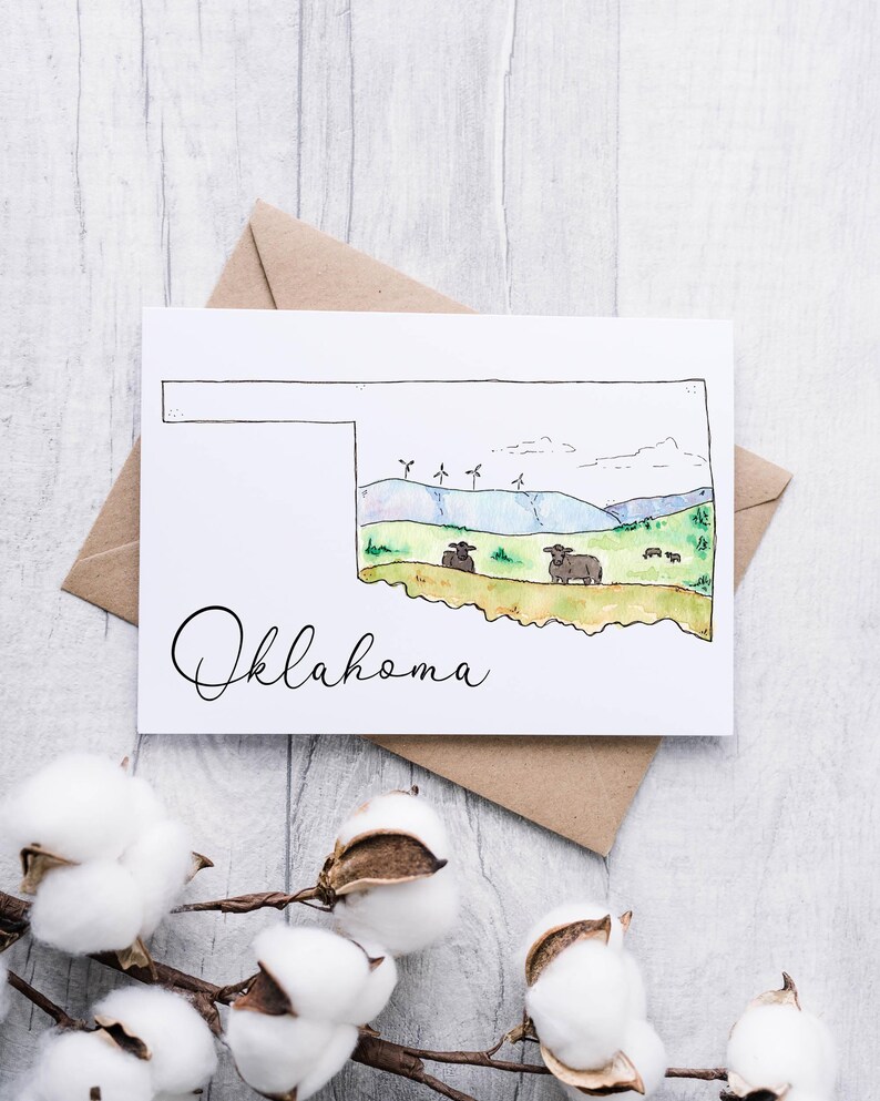 K&ouml;nnte beinhalten: Eine Aquarell-Illustration des Bundesstaates Oklahoma mit blauem Himmel, gr&uuml;nen H&uuml;geln, Windkraftanlagen und K&uuml;hen. Das Wort "Oklahoma" ist in Kursivschrift unterhalb der Staatsgrenze geschrieben.